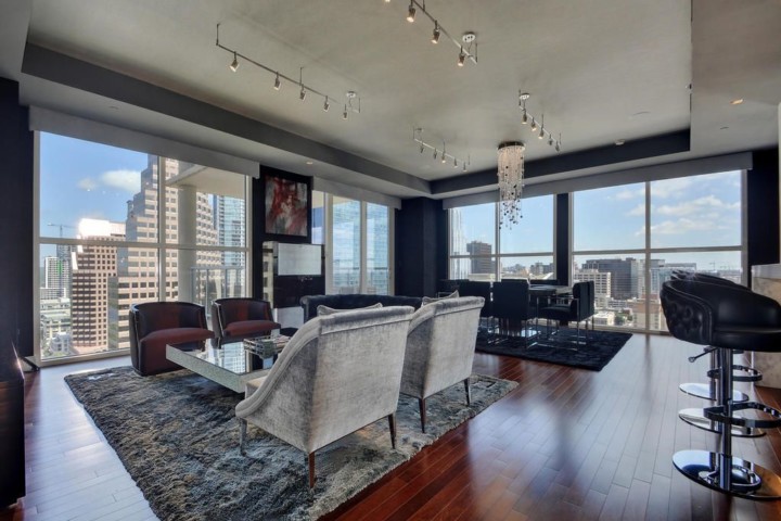 A living room with large windows and a view of the city.