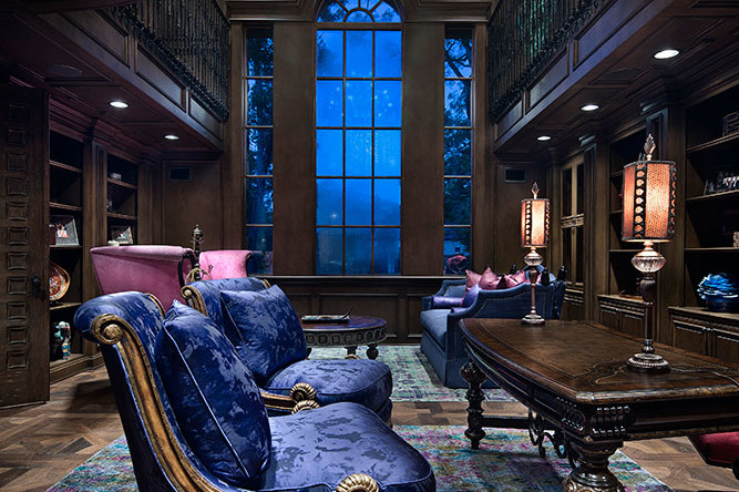 A living room with blue furniture and a large window.