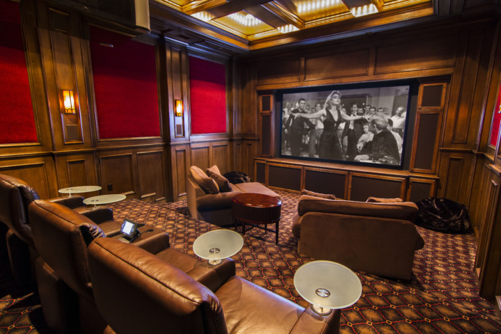 A room with leather furniture and a large screen.