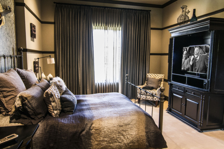 A bedroom with a bed, chair and television.