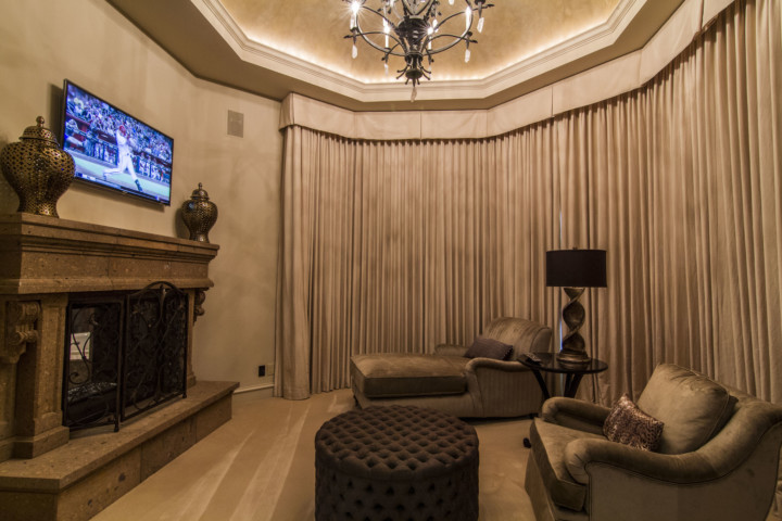 A living room with a fireplace and a television.