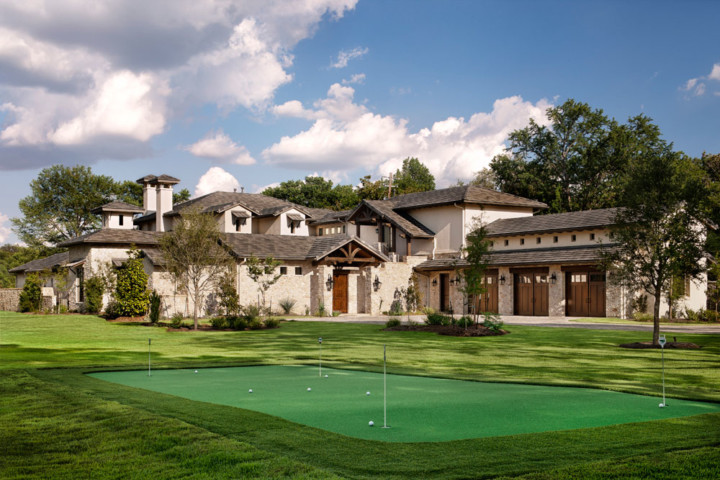 A large house with a golf course in the foreground.