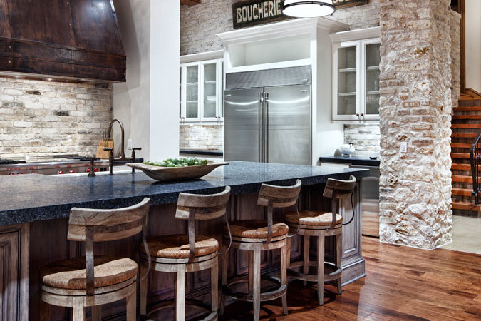 A kitchen with wooden floors and stone walls.