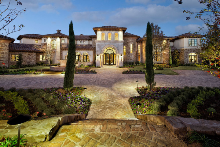 A large mansion with many trees and bushes