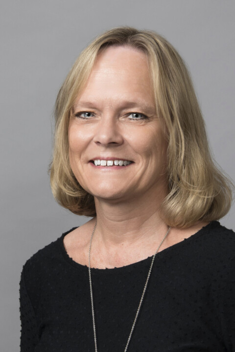 A woman with blonde hair wearing a black shirt.
