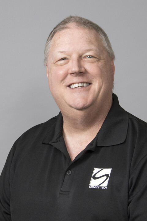 A man in black shirt smiling for the camera.