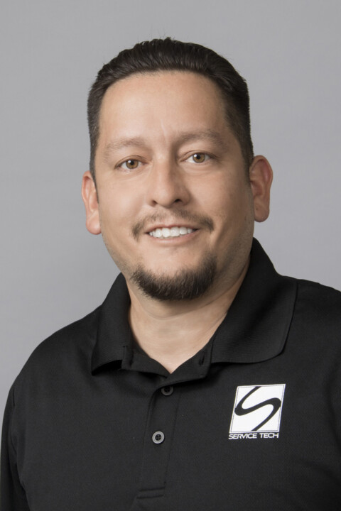 A man in black shirt smiling for the camera.