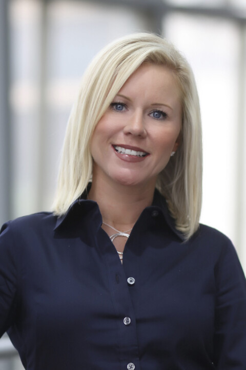 A woman with blonde hair wearing a blue shirt.