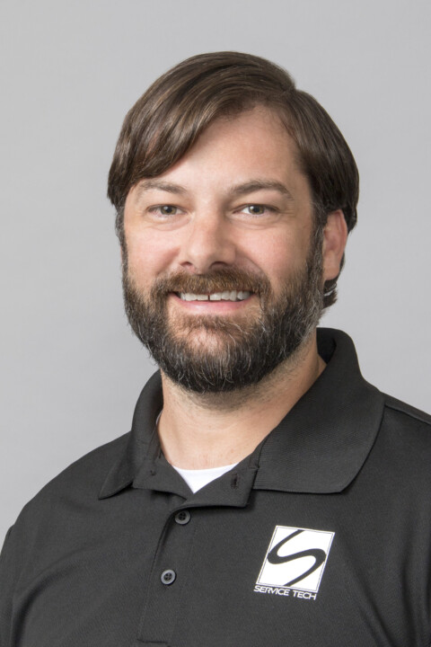 A man with long hair and beard wearing black shirt.