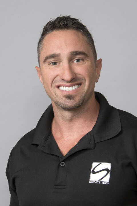 A man in black shirt smiling for the camera.
