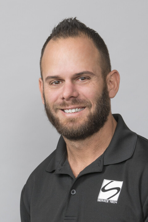 A man with a beard and smiling for the camera.