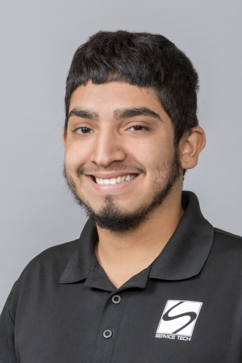 A man in black shirt smiling for the camera.