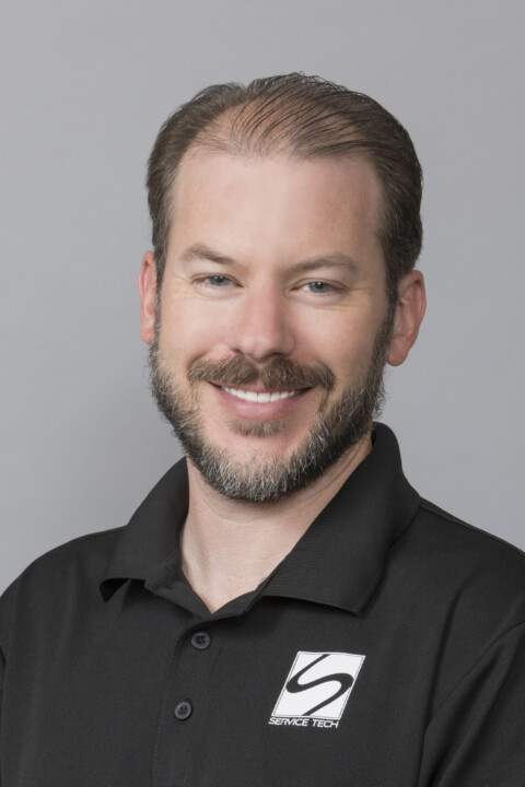 A man with a beard and mustache wearing a black shirt.