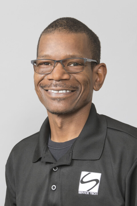A man in black shirt and glasses smiling.
