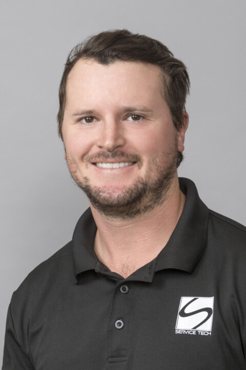 A man in black shirt smiling for the camera.