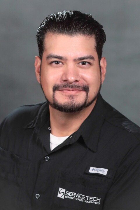 A man with a beard and mustache wearing black shirt.