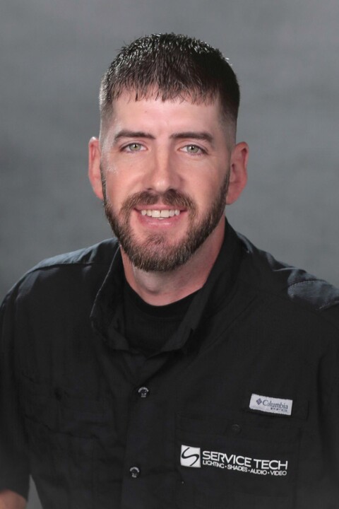 A man in black shirt smiling for the camera.