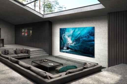 a living room with gray sofas and a flat-screen LED TV on the wall